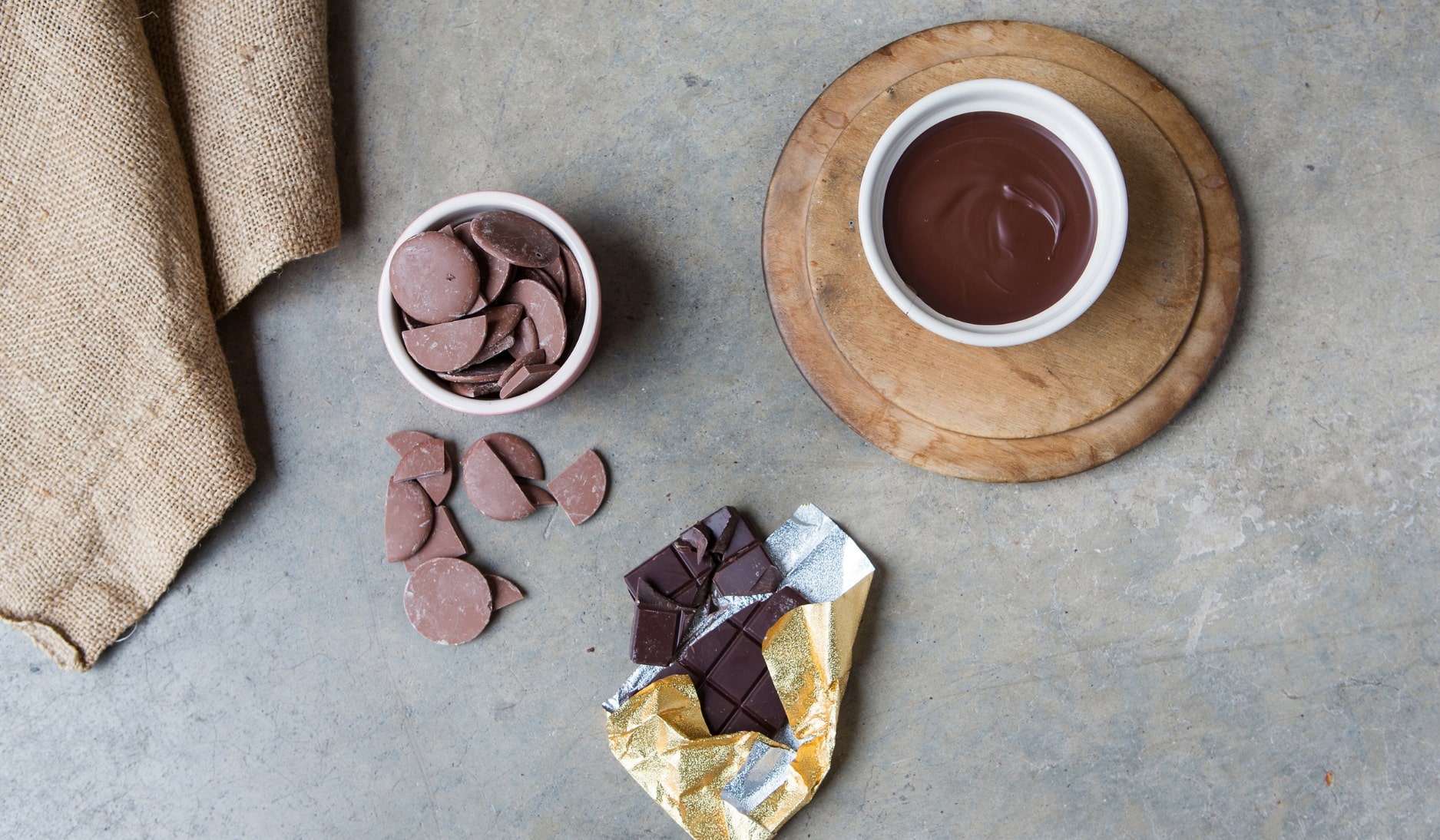 Bowl of melted chocolate next to a bowl of chocolate buttons
